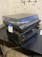 Sony A/V center digital receiver with Onkyo turntable on top shown with dust cover, power cord visible, unit powered on.