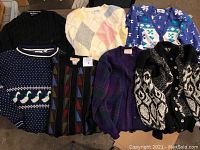 Seven vintage sweaters arranged showing various patterns and colors including black Nautica, multicolored geometric, and argyle styles.