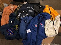 Full view of the collection showing various vintage jackets with different colors and logos including NFL Patriots and camouflage jacket.
