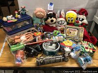 Full display of vintage toys including Barbies, plush Looney Tunes characters, novelty lunchboxes, and small toys.