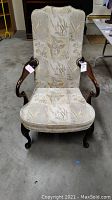 Front view of Henredon side chair showing floral patterned upholstery and polished wooden arms and legs.