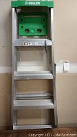 Frontal view of Keller brand aluminum ladder 6 ft with green top part and four visible steps.