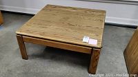 Image of the full oak coffee table showing its square shape and solid construction.