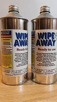 Two 1-gallon Wipe Away Heavy Duty Cleaner cans in metal containers with labels showing usage and hazard info.