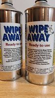 Two metal 1-gallon cans of Wipe Away industrial cleaner, showing front and side label details.