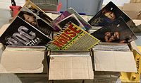 Three large open cardboard boxes filled with vertically arranged vintage 12" vinyl LP albums, showing a variety of album cover artwork.
