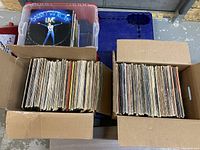 Two boxes and one plastic container filled with over 300 vintage 12-inch vinyl LP records from folk, pop, adult listening, and soundtrack genres.