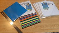 Five packs of vinyl sticker sheets including blue, white, and multi-colored striped sheets, with a ruler for scale.