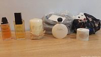 Overview of seven perfume and gift items including bottles, candle and plush toy.