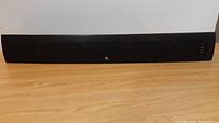 Full front view of the Boston Acoustics TVee 25 soundbar showing its black mesh grille and central branding logo.