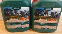 Two green 5L plastic jugs labeled CANNA Coco A and CANNA Coco B. Labels show hydroponic nutrient branding with gardening imagery.