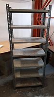Full view of gray metal shelving unit with 7 shelves assembled, showing overall condition and size in room context.