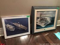 Two framed naval prints side by side against wall