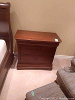 Solid wood nightstand/dresser with two dovetailed drawers, medium brown finish, rounded corners on top.