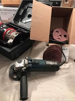 Photo of Mastercraft 4 1/2 inch angle grinder with box of sanding discs and Craftsman router in case