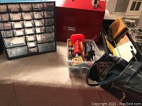 Photo showing Craftsman toolbox, hardware organizer, hand tools, and tool apron on table.