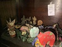Front view of shelf displaying assorted animal sculptures and carved vessels