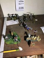 Wide shot of all five metal cat figurine groupings on wooden surface