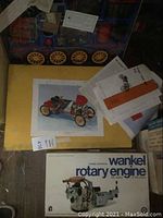 Printed artwork, instruction sheets and box cover for Fiat 130 HPF2 kit alongside Wankel rotary engine box