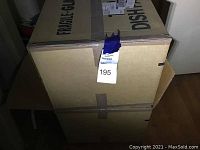 Three stacked cardboard boxes labeled 'FRAGILE GLASS' and 'DISHWASHER SAFE' indicating the boxes contain glassware items carefully wrapped inside.