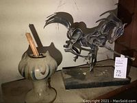 Bronze horse sculpture and ceramic vase on dusty surface