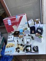 Overview of assorted cat figurines, trinket boxes, bronze sculptures, and coin sets