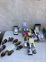 Overview of eight pewter napkin rings, porcelain boxes, sodalite cat and bronze figurines arranged on table