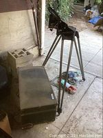 Tripod with mount head and closed carrying case on floor