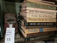 Photo of a stack of vintage books focusing on erotic art and some cultural history titles, dusty and visibly worn.