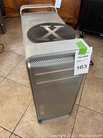 Front/top angle showing handles, black X cover, perforated front and lot tag.