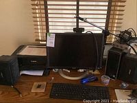 Wide view of desk setup showing Dell monitor, Canon printer, keyboard, microphone stand, and computer tower on wooden desk.