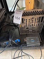 Three electronic items on rack shelf: Cubix chassis, Pyle Pro amplifier, AJA converter.