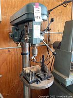 Full view of the Enco 16 Speed Drill Press with drill bits arranged on the round table.