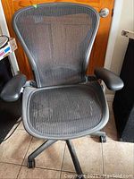 Front view of chair showing mesh seat, back, armrests and base