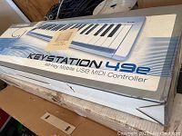 M-Audio KeyStation 49e retail box on cardboard surface