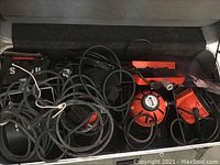 Overview of the lighting kit including orange Ianebeam lamps, multiple cables and accessories packed inside a carrying case