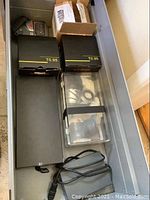 Top-down view of two black HyperPrime T0.95 lens boxes, long black box, clear organizer tray, and power adapter in tray