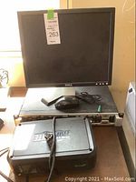 Front view of Dell 17 inch monitor with mouse placed on Peavey amplifier, Tripp Lite UPS in front.