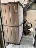 Side view of assembled plastic shed showing two-tone panels and overall shape