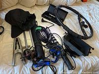 Photo of the lot items together on a bed including tripod, bag, guitar stand, microphone, cables and camera rig