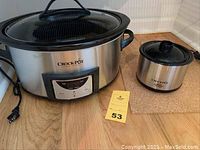 Photo of both Crock-Pots side by side showing size difference, plug cords, and overall condition.