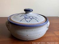 Front view of Havill Pottery bean pot with lid, showing blue horse design on lid and sculpted handles.