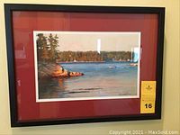 Framed print showing a scenic lake landscape with reddish mat and black frame