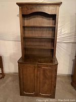Vintage solid wood hutch bookcase cabinet showing full front view including upper shelves and lower doors.