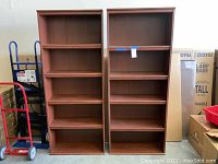 Front view of two matching wood bookcases placed side by side.