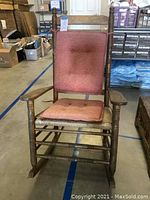 Front view of the wood rocking chair with cushions on seat and back.