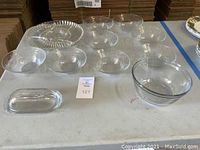 Overview of set including multiple clear glass bowls, a divided plate and a rectangular covered dish.