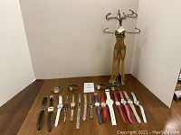 Overview of all watches and jewelry stand on a wooden table against a beige wall.