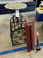Photo showing the tile top table, metal wine rack with grapevine decoration, and the candelabra with faux candle