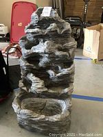 Full view of the two-piece rock look fountain showing textured rock-like tiers and basin